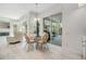 Bright breakfast nook features a glass table, white wicker chairs, and access to a living room at 3136 Sandhill Dr, Holiday, FL 34691