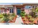 Inviting front entrance with a vibrant blue double door, lush greenery, and mulch landscaping leading to the home at 3136 Sandhill Dr, Holiday, FL 34691