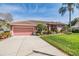 Charming single-Gathering home with a well-manicured lawn, a two-car garage, and vibrant landscaping at 3136 Sandhill Dr, Holiday, FL 34691