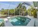 A screened-in hot tub surrounded by lush landscaping, providing a private and tranquil backyard oasis at 3136 Sandhill Dr, Holiday, FL 34691