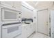 Efficient kitchen layout featuring ample counter space, microwave, oven, and access to a laundry area at 3136 Sandhill Dr, Holiday, FL 34691