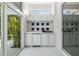 Outdoor wet bar with tile backsplash and white cabinets, perfect for entertaining by the pool at 3136 Sandhill Dr, Holiday, FL 34691