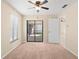 Bedroom with beige carpet, window, door leading to screened patio, and a ceiling fan at 3261 Pine Forest Dr, Palm Harbor, FL 34684