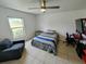 Bedroom with simple décor, featuring a comfortable bed, window, and desk setup at 3339 Avanti Cir, North Port, FL 34287