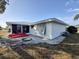Rear exterior of a home with updated siding, a screen room, and stone landscaping at 3339 Avanti Cir, North Port, FL 34287