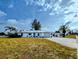 Home exterior with well-kept lawn and landscaping, including a long driveway to the garage at 3339 Avanti Cir, North Port, FL 34287