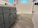 Modern bathroom features gray vanity, sleek fixtures, and gray plank flooring at 3615 Kingsbury Dr, Holiday, FL 34691