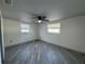 Bright bedroom with light gray flooring, neutral walls, ceiling fan, and two windows at 3615 Kingsbury Dr, Holiday, FL 34691