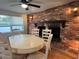 Dining room with brick fireplace, ceiling fan, sconce lighting, and a large white table at 3615 Kingsbury Dr, Holiday, FL 34691