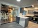 Modern kitchen with stainless steel appliances, gray cabinetry, granite countertops, and updated lighting at 3615 Kingsbury Dr, Holiday, FL 34691