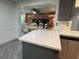 Granite countertop kitchen island overlooks dining area with a brick fireplace at 3615 Kingsbury Dr, Holiday, FL 34691