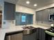 Stainless steel farmhouse sink with gray cabinets and quartz backsplash at 3615 Kingsbury Dr, Holiday, FL 34691
