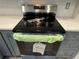 Modern GE electric range oven with stainless steel top and gray cabinets at 3615 Kingsbury Dr, Holiday, FL 34691