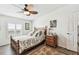 Cozy bedroom featuring hardwood floors, a comfortable bed, and a coordinated wooden dresser at 37510 New Horizons Blvd, Zephyrhills, FL 33541