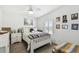 Bright bedroom with wood floors, a colorful quilt, and natural light from large windows at 37510 New Horizons Blvd, Zephyrhills, FL 33541