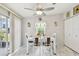 Bright dining room features a modern ceiling fan, white table set, and sliding door access to the outside at 37510 New Horizons Blvd, Zephyrhills, FL 33541