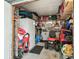 Garage features a refrigerator, lawn mower, storage cabinets, and various supplies at 37510 New Horizons Blvd, Zephyrhills, FL 33541