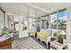 Bright sunroom with white wicker furniture, plush yellow cushions, and plenty of natural light at 37510 New Horizons Blvd, Zephyrhills, FL 33541