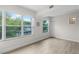 Bright bedroom featuring wood floors, large windows with green views, and white trim and walls at 4151 55Th N Way # 1056, Kenneth City, FL 33709