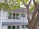 Exterior of the second story condo unit featuring large windows and an outdoor balcony at 4151 55Th N Way # 1056, Kenneth City, FL 33709