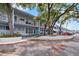 Condo building exterior showcasing mature trees, reserved parking, and well-maintained grounds at 4151 55Th N Way # 1056, Kenneth City, FL 33709