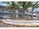 Charming exterior of the condo building with mature trees and landscaping at 4151 55Th N Way # 1056, Kenneth City, FL 33709