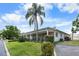 Charming house showcasing a lush green lawn with tropical trees at 4151 55Th N Way # 1056, Kenneth City, FL 33709