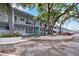 Condo building exterior showcasing mature trees, reserved parking, and well-maintained grounds at 4151 55Th N Way # 1056, Kenneth City, FL 33709