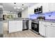 Bright kitchen with stainless appliances, granite counters and blue LED lighting at 4151 55Th N Way # 1056, Kenneth City, FL 33709
