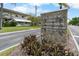 Street view of community signage with lush landscaping in front at 4151 55Th N Way # 1056, Kenneth City, FL 33709