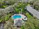 Gorgeous aerial view of the pool, hot tub, and backyard of this home surrounded by lush greenery at 4208 Edgewood Dr, Holiday, FL 34691