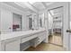 Spacious bathroom featuring a large vanity with double sinks, large mirror and mirrored closet doors to the bedroom at 4208 Edgewood Dr, Holiday, FL 34691