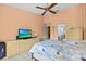 Bright bedroom with a ceiling fan, tiled floor, and a connected bathroom at 4208 Edgewood Dr, Holiday, FL 34691
