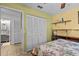 Bedroom featuring wooden bed frame and closet access to a bright bathroom with modern gray finishes at 4208 Edgewood Dr, Holiday, FL 34691