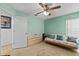 Bright bedroom featuring tile flooring, a light green wall, a ceiling fan, and natural light at 4208 Edgewood Dr, Holiday, FL 34691