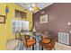 Colorful dining room featuring a glass table, wicker chairs and unique decorative art at 4208 Edgewood Dr, Holiday, FL 34691