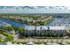 Aerial view of waterfront condos with boat docks, palm trees, and a blue sky background at 459 Bahia Beach Blvd, Ruskin, FL 33570