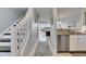 Hallway with staircase with partial view of kitchen and living space with sliding glass door to a balcony at 459 Bahia Beach Blvd, Ruskin, FL 33570