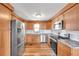 Bright kitchen featuring stainless steel appliances, white subway tile backsplash, and wood cabinets at 4851 W Gandy Blvd # B3 L8, Tampa, FL 33611