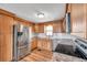 Bright kitchen featuring stainless steel appliances, white subway tile backsplash, and wood cabinets at 4851 W Gandy Blvd # B3 L8, Tampa, FL 33611
