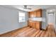 A cozy kitchenette features wood cabinets, a tile backsplash, and wood-look flooring at 4851 W Gandy Blvd # B3 L8, Tampa, FL 33611