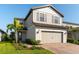 Charming two-story home featuring a well-manicured lawn, neutral siding, and an attached two-car garage with brick paver driveway at 6223 Baywood Ct, Bradenton, FL 34211
