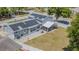 Aerial view of a backyard featuring solar panels, a paved patio, a basketball hoop and a screened enclosure at 7015 Cobblewood Ct, Tampa, FL 33615