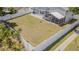 An aerial view shows a spacious, fenced backyard with green lawn, landscaping, and a screened-in patio at 7015 Cobblewood Ct, Tampa, FL 33615