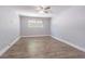 Empty bedroom with wood-look floors, a ceiling fan and a window with natural light at 7015 Cobblewood Ct, Tampa, FL 33615