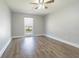 Bedroom with wood-look floors, ceiling fan and a window with natural light at 7015 Cobblewood Ct, Tampa, FL 33615