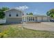 Inviting home showcases a welcoming front door, brick entryway, and manicured lawn on a sunny day at 7015 Cobblewood Ct, Tampa, FL 33615
