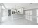 Open kitchen and living area features white cabinets, modern appliances, and marble tile flooring at 7015 Cobblewood Ct, Tampa, FL 33615