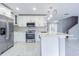 Modern kitchen features stainless steel appliances, white cabinetry, and marble countertops at 7015 Cobblewood Ct, Tampa, FL 33615