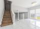 Open-concept living area featuring tile flooring, stairs, and a bright window, blending modern design at 7015 Cobblewood Ct, Tampa, FL 33615